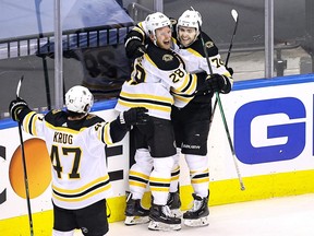 Jake DeBrusk, top right, of the Boston Bruins is congratulated by his teammates after scoring a goal at 14:17 against the Carolina Hurricanes during the third period in Game 4 of the Eastern Conference First Round during the 2020 NHL Stanley Cup Playoffs at Scotiabank Arena on Aug. 17, 2020 in Toronto.