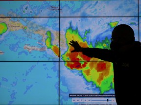 A member of the Emergency Operations Committee (COE) monitors the trajectory of Storm Laura in Santo Domingo, Dominican Republic Aug. 22, 2020.
