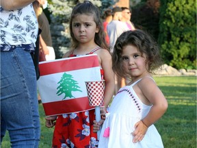 Angelina, left, and Josephine Haddad participate with their mother and other members of the local Lebanese community during a candlelight vigil for those killed and injured in the massive port explosion in Beirut, Lebanon. About 150 gathered in Dieppe Park in downtown Windsor on Friday night, Aug. 7, 2020.