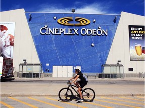 A cyclist passes the exterior of Cineplex Odeon theatres at Devonshire Mall in Windsor on Thursday, Aug. 13, 2020, a day before the business was set to resume operations after a five-month shutdown due to COVID-19.