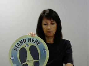 Windsor-Essex County Health Unit CEO Theresa Marentette holds up new signage created by area businesses to help visitors physically distance during a virtual news conference on Thursday, August 13, 2020.