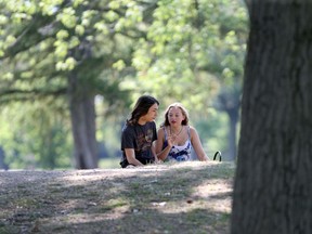 Enjoying a spot in the shade, Owen Bruce and Hope Neill picnic together on a warm, summer afternoon at Willistead Park on Monday, Aug. 24, 2020.