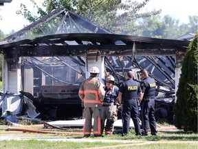 OPP and Essex fire officials gather at the scene of a garage fire on County Road 12 at Brush Side Road Sunday morning.  The garage was destroyed as were two vehicles inside. Over a dozen firefighters responded to the blaze as did Essex-Windsor EMS paramedics.