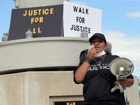 Joi Hurst speaks on the microphone during the Walk for Justice at Dieppe Park Sunday, Aug. 30, 2020.
