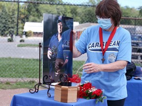 Candice Tremblay, wife of Jim Tremblay who passed away June 29, 2020, adjusts a portrait of her husband, a longtime volunteer with Windsor Central Little League. A special visitation service was held at Optimist Park ball diamond Sunday.
