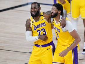 Los Angeles Lakers' LeBron James (23) and Anthony Davis (3) celebrate after defeating the Denver Nuggets 124-121 during an NBA basketball game Monday, Aug. 10, 2020, in Lake Buena Vista, Fla. at AdventHealth Arena.
