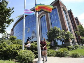 Scarlet Gagnier-Nickart, left, and A.J. Lecuyer raise the flags during the Pride Month 2020 flag-raising ceremony held Monday outside  the Windsor-Essex Children's Aid Society headquarters on Riverside Drive.