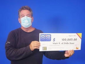 Mark Hillman of Belle River with his $100,000 prize cheque from playing ENCORE on a Lotto MAX ticket, June 2020.