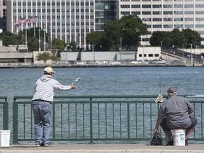 Wayne Andreas, left, and Nelson Toner fish in the Detroit river in downtown Windsor, ON. on Friday, August 7, 2020.