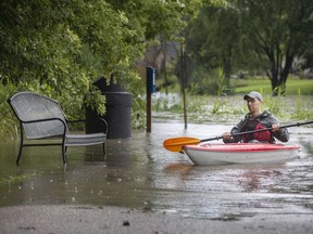 Simon Shanfield kayaks the pathway next to a swollen Turkey Creek in LaSalle on Friday, Aug. 28, 2020, as the region received a significant amount of rain.