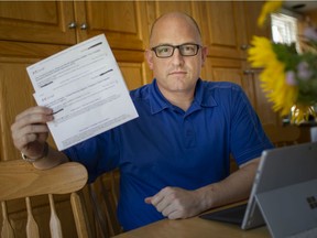 Windsor Mayor Drew Dilkens, pictured at his home, Thursday, Aug. 20, 2020, holds up printed emails involved in the hacking of his CRA account.