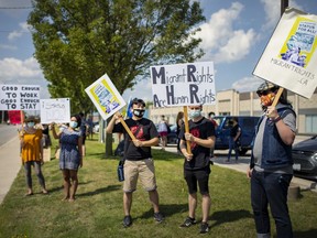 A group of approximately two dozen people rallied outside Windsor's Immigration, Refugees and Citizenship Canada facility on Walker Road to demand better rights for migrants, Sunday, August 23, 2020.