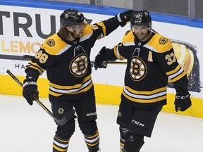 Bruins centre Patrice Bergeron (right) celebrates with right wing David Pastrnak (left) his power-play goal against the Hurricanes during the second period in Game 5 of the first round of the 2020 Stanley Cup Playoffs at Scotiabank Arena in Toronto, Wednesday, Aug. 19, 2020.