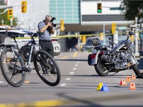 Investigators with the Special Investigative Unit, work at the scene of a collision between a person riding a motorcycle and a police officer from the bicycle unit at the intersection of Wyandotte Street East and McDougall Street on Wednesday, August 19, 2020.