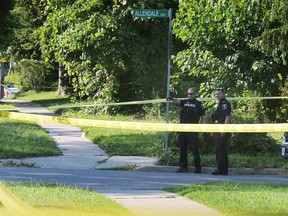 Windsor police officers investigate a blood trail on a sidewalk on Howard Avenue on Aug. 8, 2020.