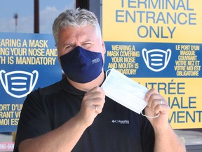 Masks covering both mouth and nose will be mandatory at the Windsor airport terminal when flights resume starting Sept. 8, 2020.  In photo, YQG CEO Mark Galvin displays new signage and masks Thursday.