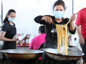 Windsor, Ontario. September 4, 2020. Leny Inting of Tropical Hut prepares noodles and chicken during Windsor Eats Food Hall event at Lanspeary Park Lions Rink Friday.  The outdoor venue has four food vendors with dining picnic tables spaced apart from each other.  (NICK BRANCACCIO/Windsor Star)