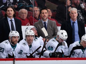 GLENDALE, ARIZONA - JANUARY 14: Coaches (top L-R) Mike Ricci, head coach Bob Boughner and Roy Sommer of the San Jose Sharks watch from the bench during the third period of the NHL game against the Arizona Coyotes at Gila River Arena on January 14, 2020 in Glendale, Arizona. The Coyotes defeated the Sharks 6-3.