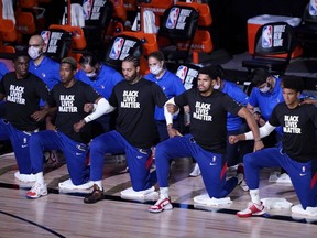 Philadelphia 76ers players kneel in honour of the Black Lives Matter movement during the national anthems prior to an NBA game against the Toronto Raptors at The Field House at ESPN Wide World Of Sports Complex on August 12, 2020 in Lake Buena Vista, Florida. (Photo by Ashley Landis-Pool/Getty Images)