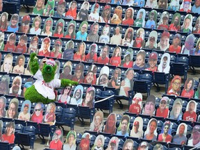 The Phillie Phanatic shows off the foul ball he caught amongst the cardboard cutout fans. The Detroit Lions plan to do the same at Ford Field.