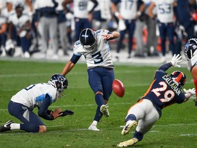 Stephen Gostkowski of the Tennessee Titans kicks a go-ahead fourth quarter field goal as Brett Kern holds and Bryce Callahan of the Denver Broncos covers the play during a game at Empower Field at Mile High on September 14, 2020 in Denver, Colorado.