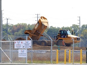 Massive haulers deliver fill to part of the Gordie Howe International Bridge complex in West Windsor Wednesday.