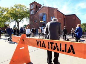 Parishioners and visitors attend an outdoor mass at St. Angela Merici Catholic Church on Erie Street East Saturday.
