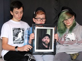 Children of Windsor homicide victim Thomas "T.J." McIntyre hold a framed photo of their father on Sept. 30, 2020. McIntyre died from injuries suffered in a fight on Seminole Street on Sept. 23, 2020. Another Windsor man has been charged with second-degree murder. From left: Riley McIntyre, 14; Coleton McIntyre, 9; and Trinity McIntyre, 17.