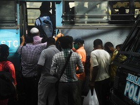 Commuters rush to catch a public bus without maintaining social distancing despite fears over the spread of the COVID-19 coronavirus, in Kolkata on Sept. 21, 2020.