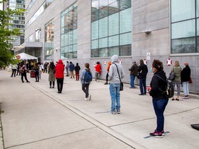 People wait in line at the Women's College COVID-19 testing facility in Toronto, Sept. 18, 2020.