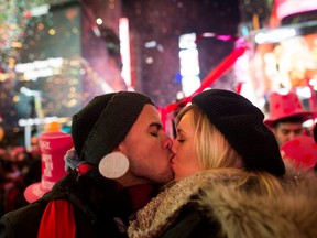 Rhea Coulson, 20, and Angel Garcia, left, from Florida kiss at midnight as they celebrate the new year in Times Square on Jan. 1, 2015 in New York City.