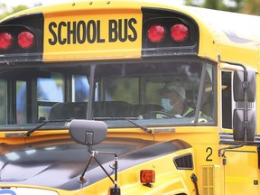 A masked bus driver pulls out of Ecole L'Envolee in Windsor on Sept. 9, 2020.