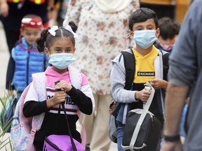 The new look for school this year includes — face masks. Students at Ecole Elementaire L'Envolee in Windsor walk to a school bus after classes on Wednesday, Sept. 9, 2020. The public french school started classes on Tuesday, while most other schools begin classes Thursday.