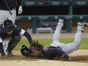 Cleveland Indians third baseman Jose Ramirez is tagged out by Detroit Tigers catcher Austin Romine (left) as he tries to steal home plate during the fourth inning at Comerica Park.