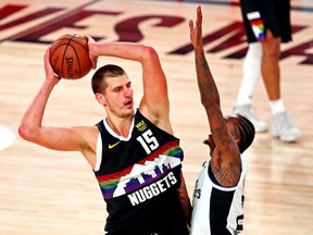 Denver Nuggets center Nikola Jokic handles the ball against LA Clippers guard Lou Williams during the third quarter in game six of the second round of the 2020 NBA Playoffs at ESPN Wide World of Sports Complex.