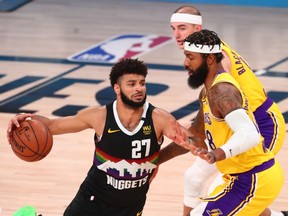 Denver Nuggets guard Jamal Murray dribbles the ball around Los Angeles Lakers forward Markieff Morris during the second half in game four of the Western Conference Finals of the 2020 NBA Playoffs at AdventHealth Arena.