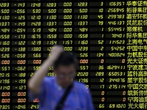 FILE PHOTO: An investor stands in front of an electronic board showing stock information at a brokerage house in Shanghai, China, August 24, 2015. Chinese stocks dived more than 8 percent on Monday morning, with the Shanghai index giving up all its gains for the year on investor disappointment that Beijing held back expected policy support at the weekend after markets shed 11 percent last week.