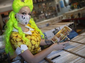 Employee Jessie Mason, dressed as Lemon, flips through a copy of Lumberjanes, at Rogues Gallery Comics on the first of three Free Comic Book Days, Friday, September 11, 2020.