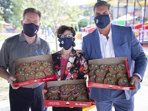 From left, Steve Salmons, President and CEO, Windsor Port Authority, Jessica Sartori, CEO, John McGivney Children's Centre, and Mike Brain, Board President, W.E. Care for Kids, pose for a photo with boxes of Tim Horton's Smile Cookies after announcing the Port Authority purchased 1200 cookies to hand out to the 846 essential port workers, Thursday, September 17, 2020.