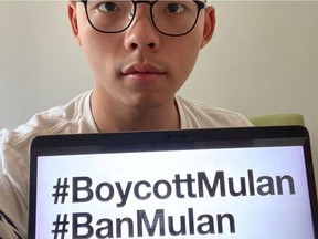 Pro-democracy activist Joshua Wong holds a monitor with hashtags BoycottMulan and BanMulan written on it, in Hong Kong, Sept. 5, 2020 in this picture obtained from social media.