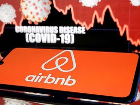 Airbnb logo is seen in front of displayed coronavirus disease (COVID-19) in this illustration taken March 19, 2020.