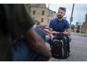 Outreach worker Colm Holmes from Family Services speaks with a person experiencing homelessness in downtown Windsor, Tuesday, September 1, 2020.