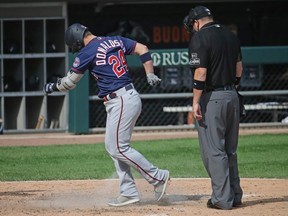 Josh Donaldson of the Twins drags dirt onto home plate as umpire Dan Bellino looks on after hitting a home run following an argument over a called strike in the 6th inning against the White Sox at Guaranteed Rate Field in Chicago, Thursday, Sept. 17, 2020.