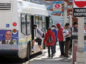 Transit Windsor riders board the bus using the rear door at the downtown bus terminal Thursday.