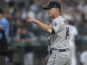 Houston Astros manager AJ Hinch gestures to the bullpen to replace starting pitcher Brad Peacock of the Houston Astros with relief pitcher Framber Valdez of the Houston Astros during the second inning of a game against the Seattle Mariners at Safeco Field on August 21, 2018 in Seattle, Washington.