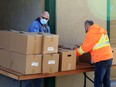 Windsor Goodfellow volunteer Brian Beaumont, right, is joined by an unidentified volunteer during Saturday's no-questions-asked event on Park Street West.