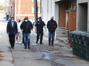 From left to right: Barry Horrobin, director of planning and physical resources for Windsor police; Ward 4 Coun. Chris Holt; Insp. David DeLuca of Windsor police; and Filip Rocca, owner of Mezzo Ristorante on Erie Street East walk through an alley in Windsor's Via Italia on Oct. 21, 2020.