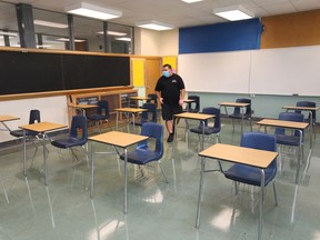 Custodian Tom Rajic makes a few adjustments in a secondary school classroom at W. F. Herman Academy on Aug. 25, 2020.