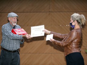 Bill Lessard receives a Foster Parent Years of Service Award and a Tim Hortons Decorate Your Own doughnut kit from Darcy Thachuk of the local Children's Aid Society on Friday, Oct. 23, 2020. Bill and Delores Lessard have been foster parents for 30 years, and there's a need for more foster homes locally.