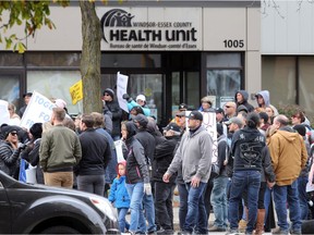 Windsor, Ontario. October 25, 2020. Over 100 demonstrators marched to the Windsor-Essex Health Unit on Ouellette Avenue Sunday afternoon.  A majority of the group were not wearing face coverings or masks and gathered in close quarters to listen to speakers. (Windsor Star photo)